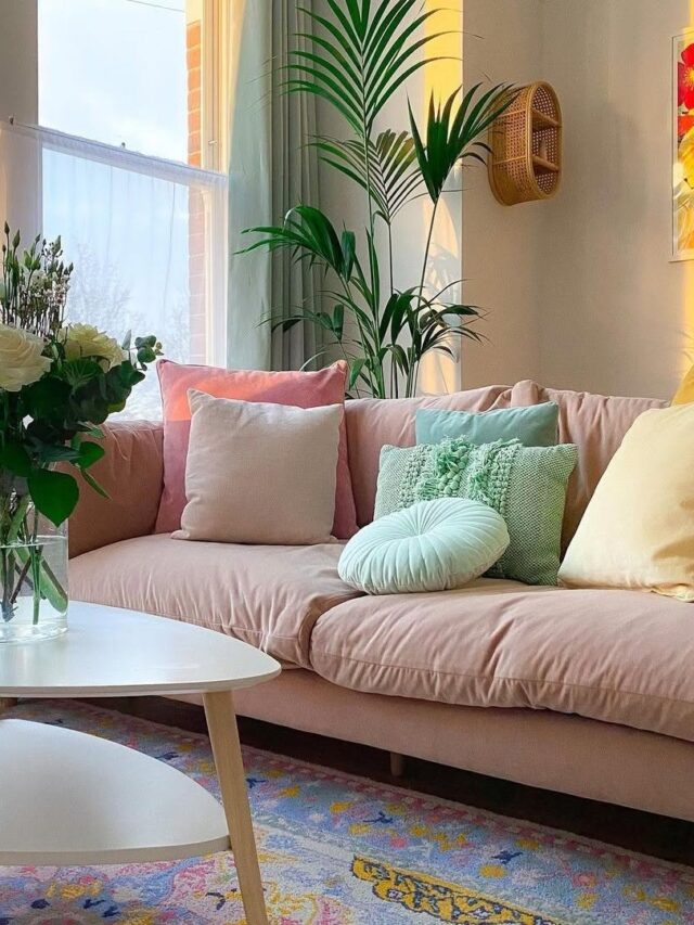 Sala de estar com sofá rosa claro e almofadas amarelas, rosas e verdes