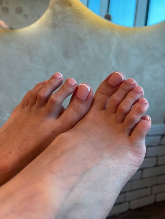 Pés de pele clara, com unhas delicadas