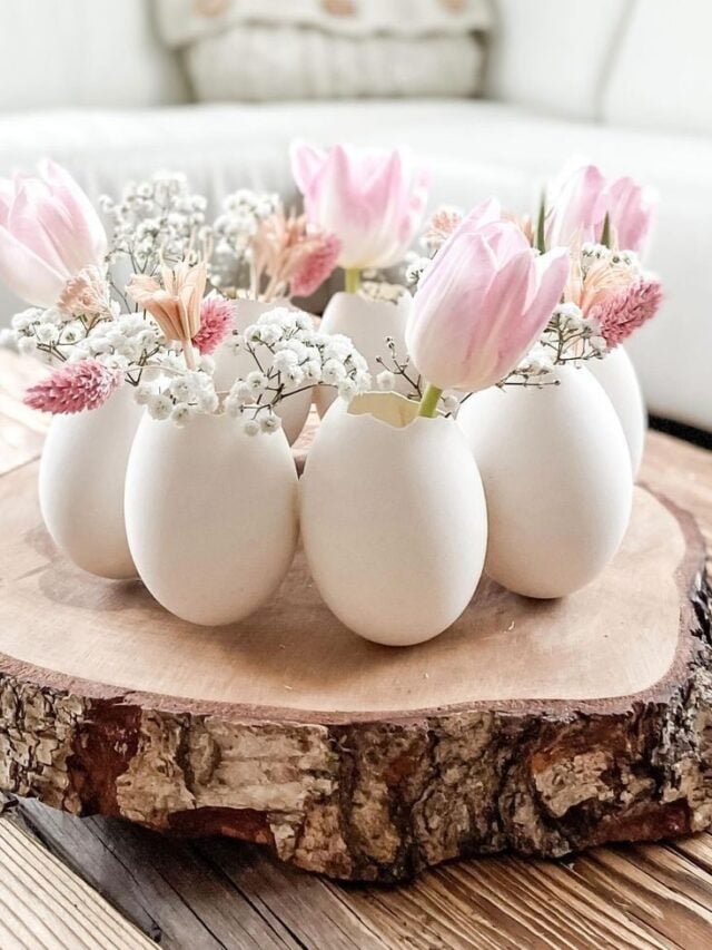 Cascas de ovos como decoração em mesa de centro. Na parte de dentro do ovo tem flores rosas.