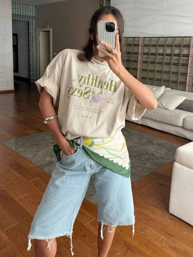Mulher jovem e magra com look com lenço na cintura.
