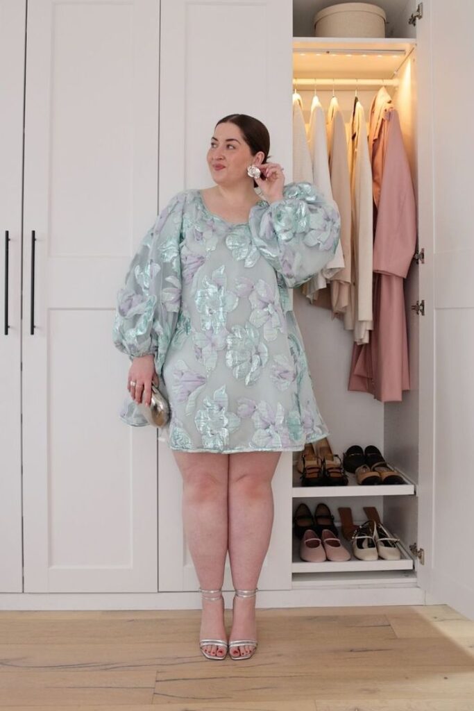 Mulher jovem de pele clara com vestido azul com flores.