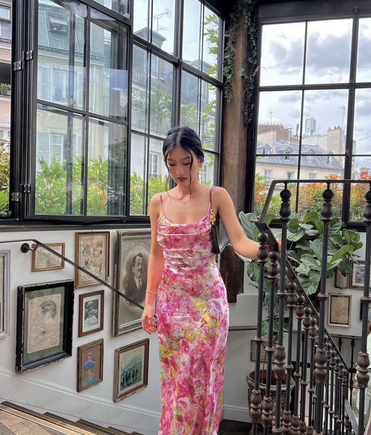 Mulher jovem e magra com look de convidada de casamento floral.