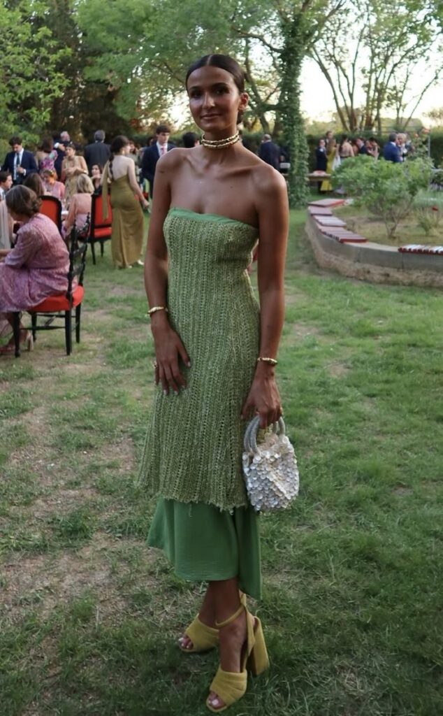Mulher jovem e magra com vestido verde sem alças.