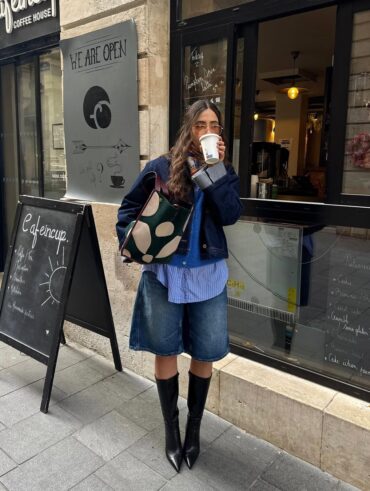 Mulher jovem com look com bermuda jeans e botas de cano longo