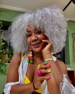 Mulher negra com cabelo médio, crespo e grisalho