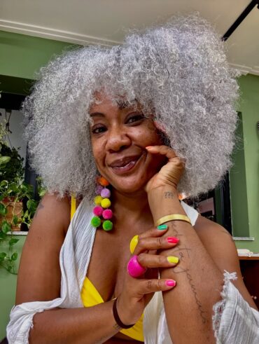 Mulher negra com cabelo médio, crespo e grisalho