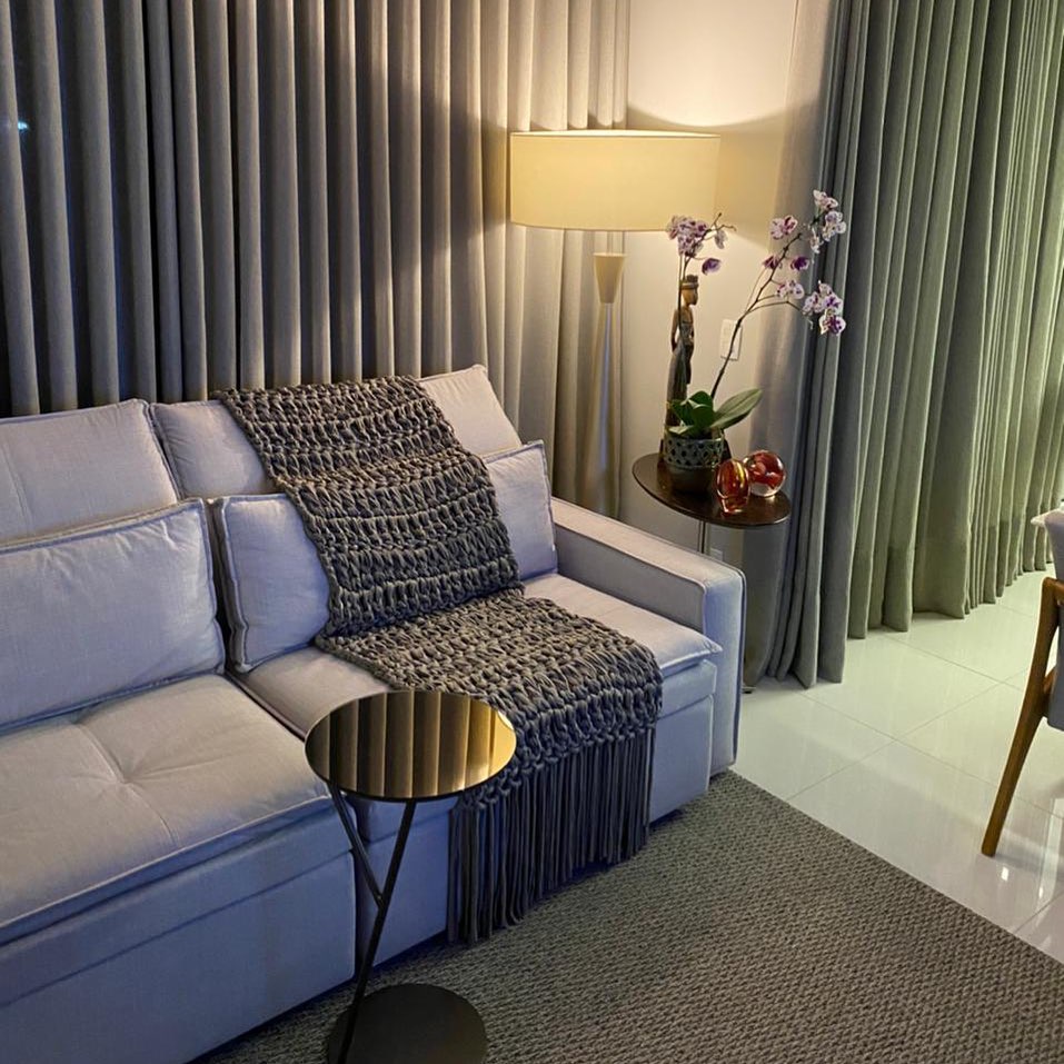 Sala de estar com sofá cinza e manta de crochê cinza