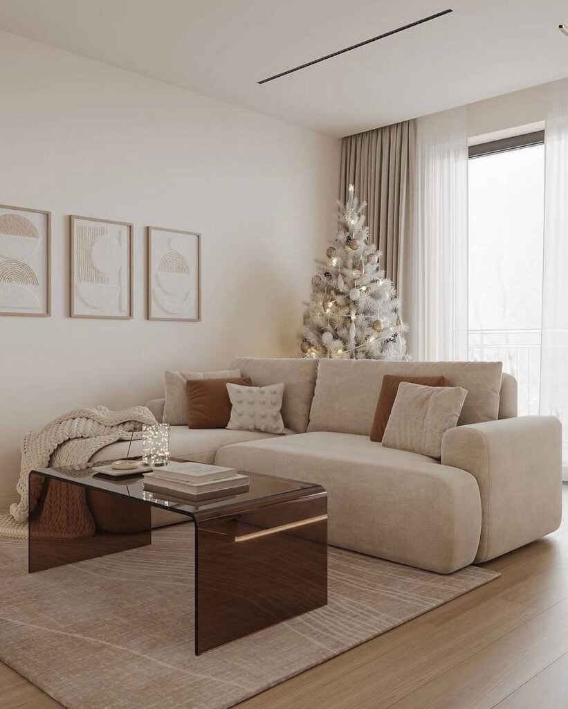 Sala de estar em tons neutros com sofá bege, almofadas bege e marrom e quadros na parede