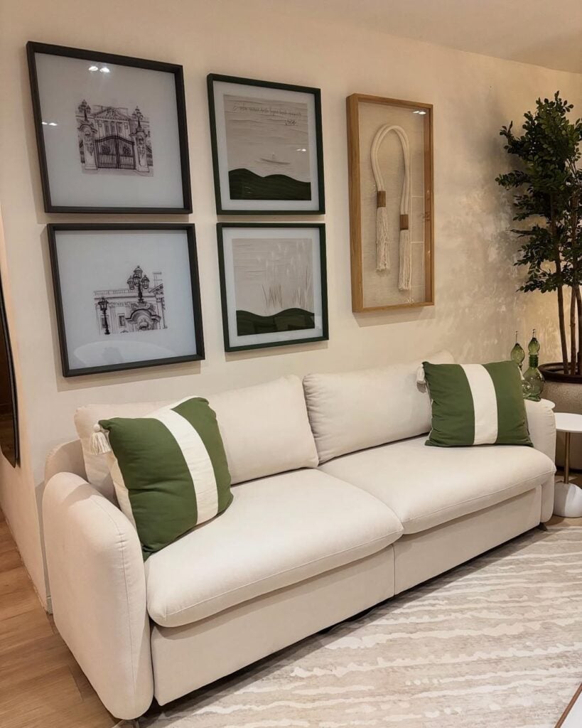 Sala com sofá claro com linhas orgânicas, e almofadas verdes com listras brancas