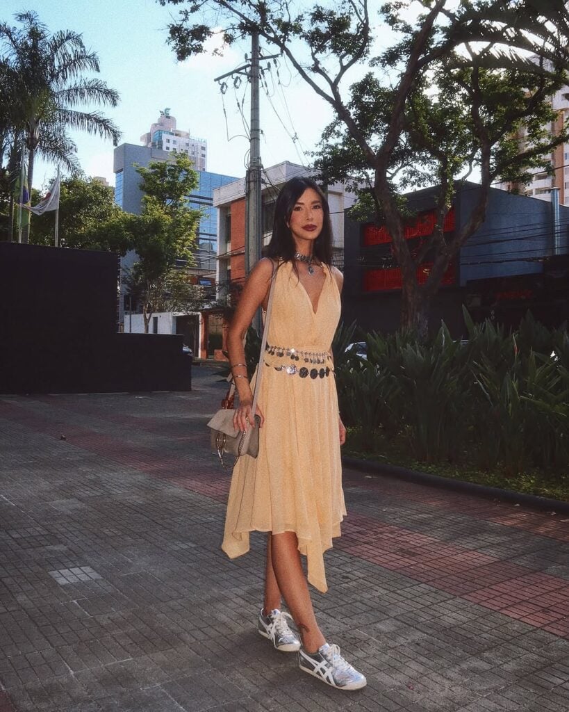 Rica de Maré, com vestido fluido amarelo, e dois cintos