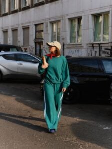 Mulher de pele clara, com conjunto de moletom verde