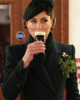 Kate Middleto, com look verde, segurando um copo com as unhas sem esmalte