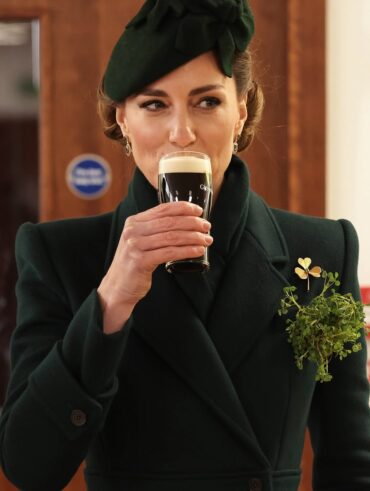 Kate Middleto, com look verde, segurando um copo com as unhas sem esmalte