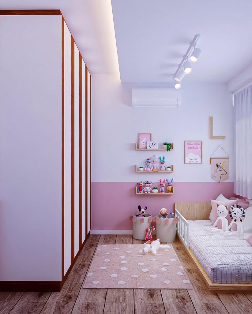 Quarto branco com meia parede rosa, cama baixa e cestos com brinquedos