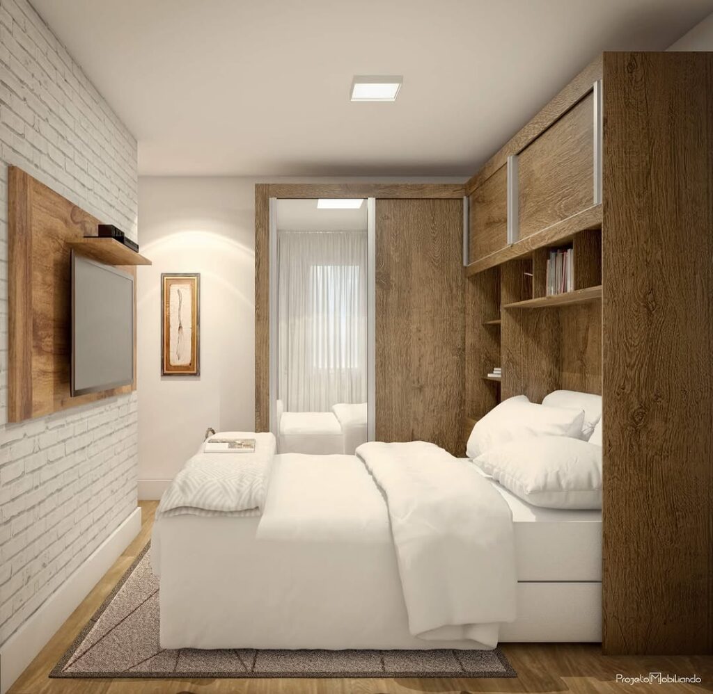 Quarto com roupeiro e prateleiras em madeira, paredes e roupas de cama brancas