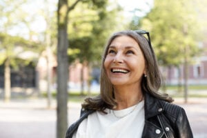 Mulher de 40 anos e cabelos grisalhos sorrindo