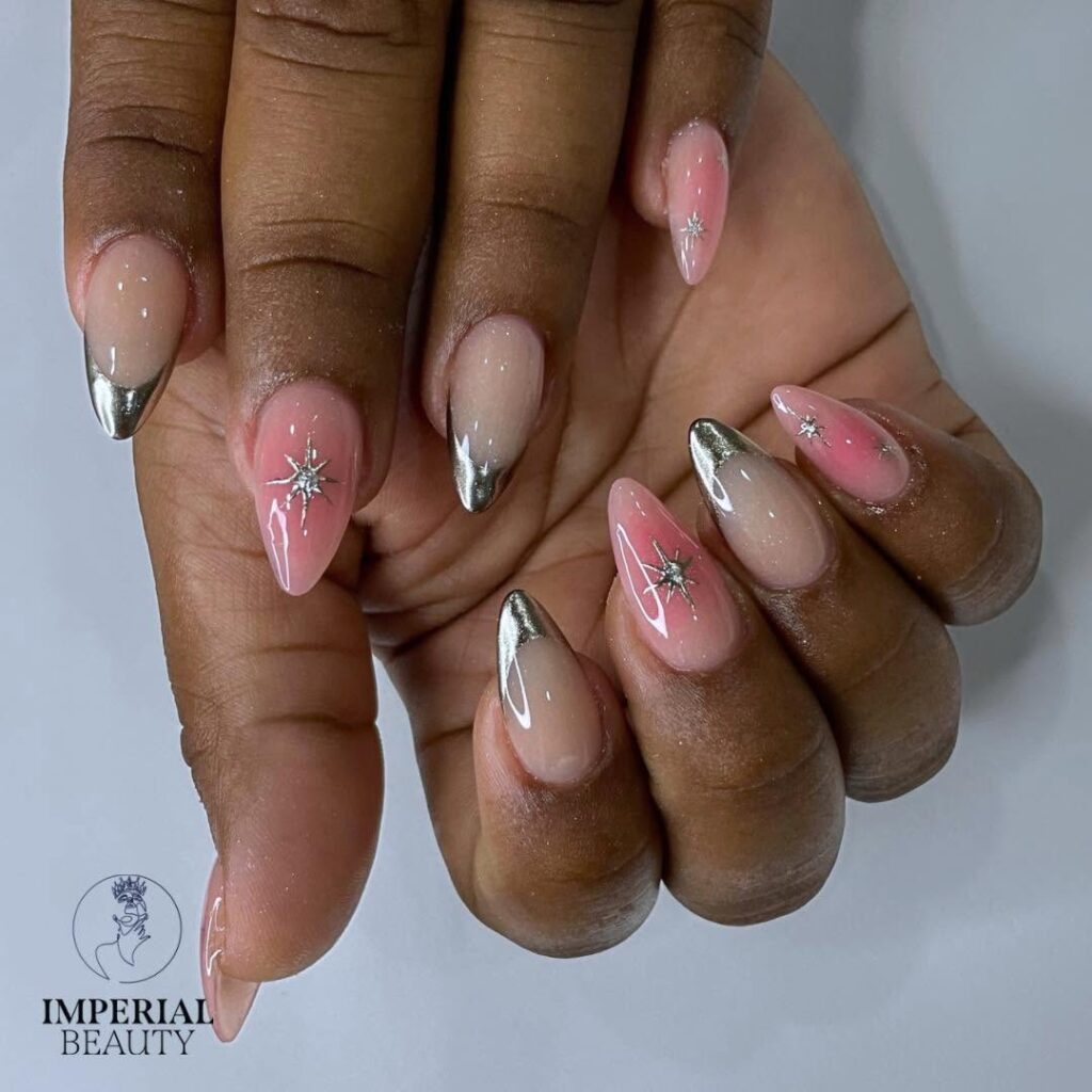 Mão de pele negra, com unha longa e amendoada, com nail art cromada prata e esfumado rosa