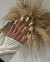 Mão de pele clara, com unha quadrada longa ombré com esmalte branco