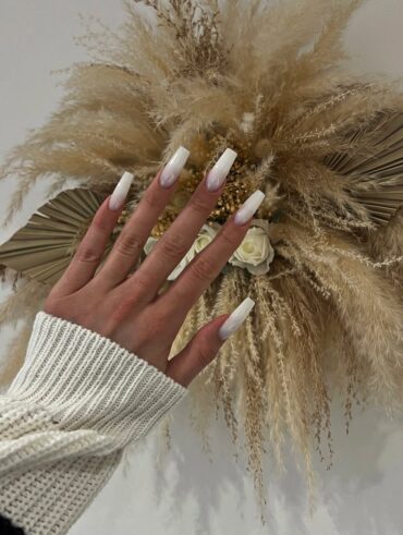 Mão de pele clara, com unha quadrada longa ombré com esmalte branco