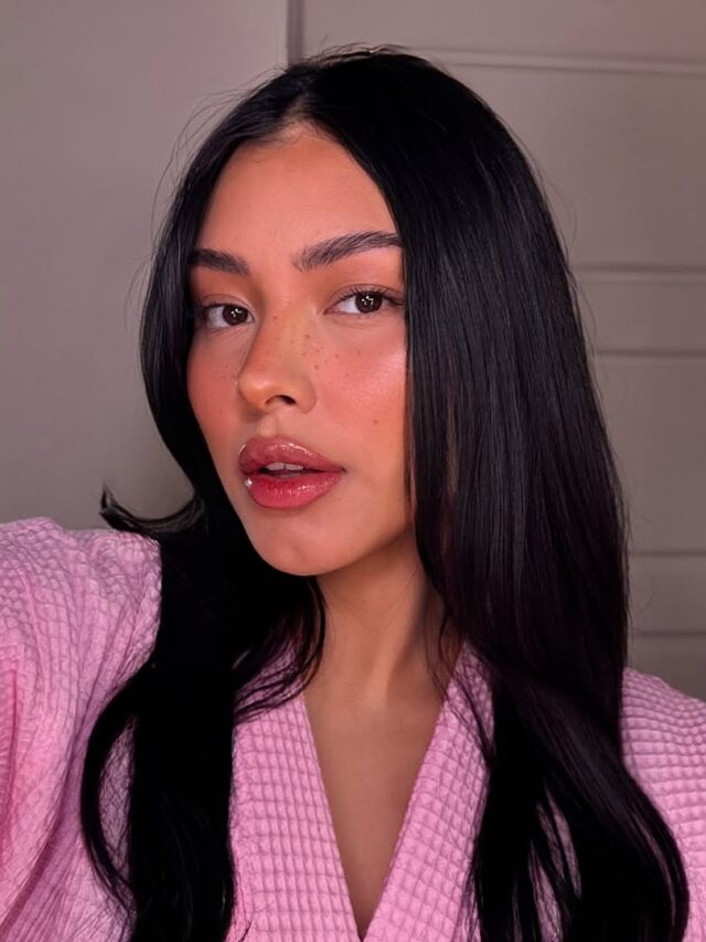 Mulher de pele clara, com roupa rosa, cabelo preto e lábios rosados