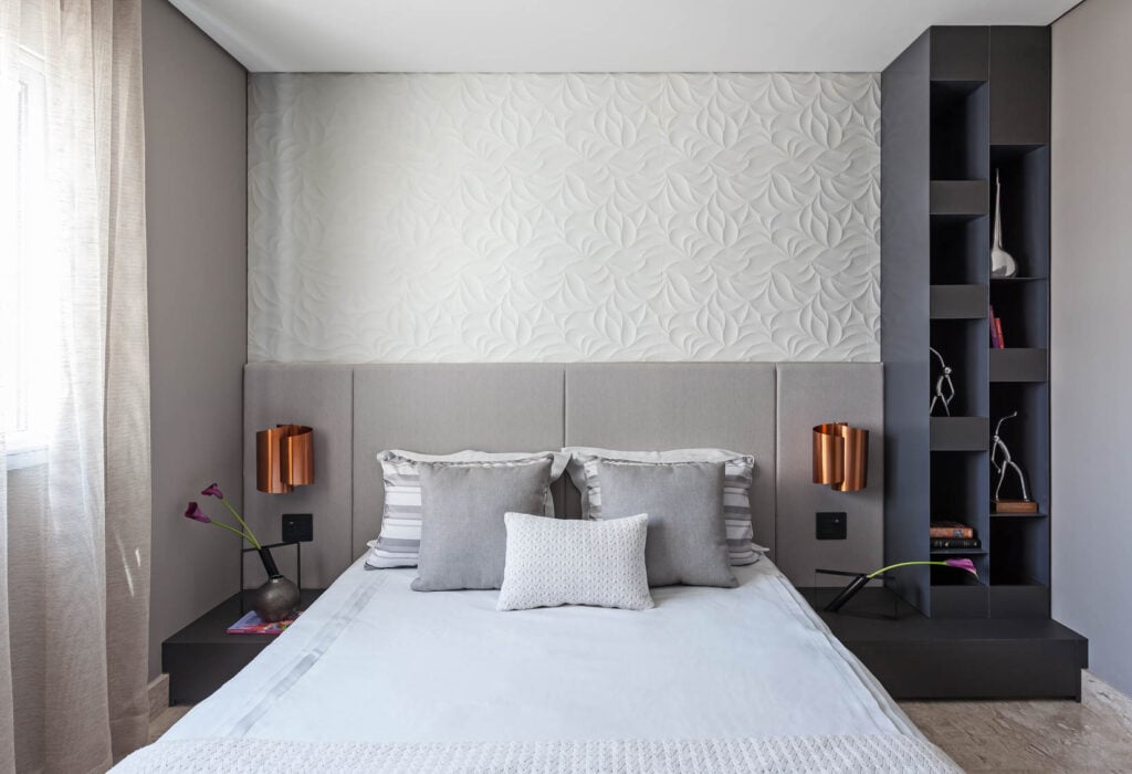 Quarto com parede em 3d, cabeceira estofada modular cinza e arandelas metálicas