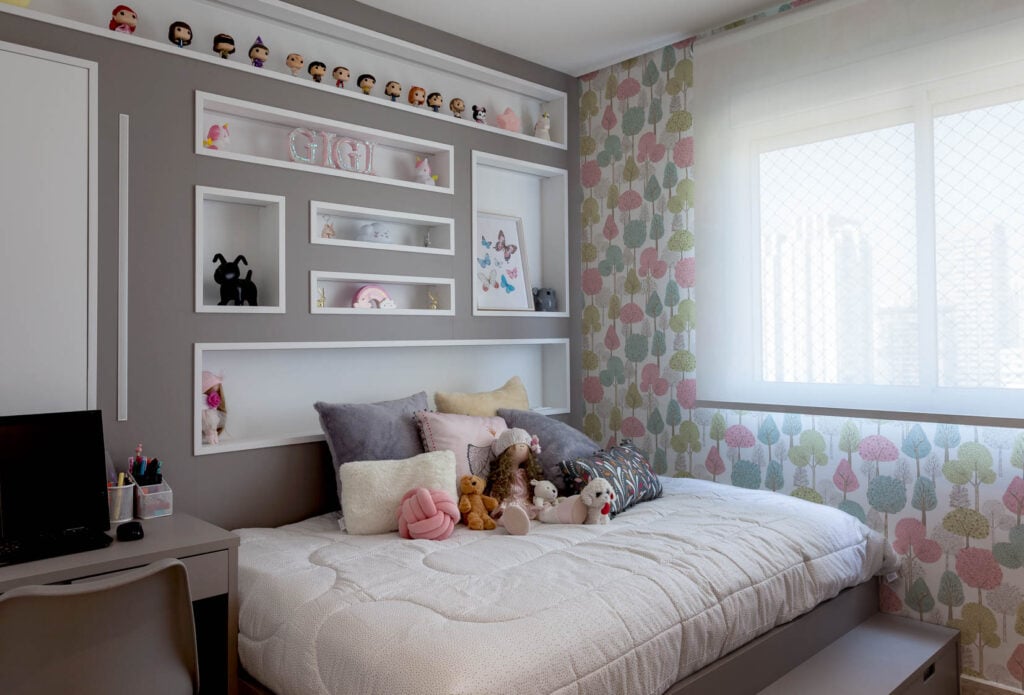 Quarto infantil com cama espaçosa e nichos na cabeceira com enfeites