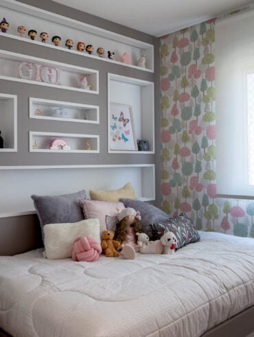 Quarto infantil com cama espaçosa e nichos na cabeceira com enfeites