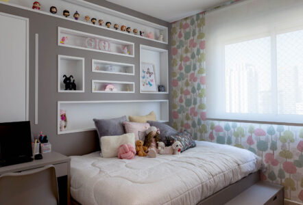 Quarto infantil com cama espaçosa e nichos na cabeceira com enfeites