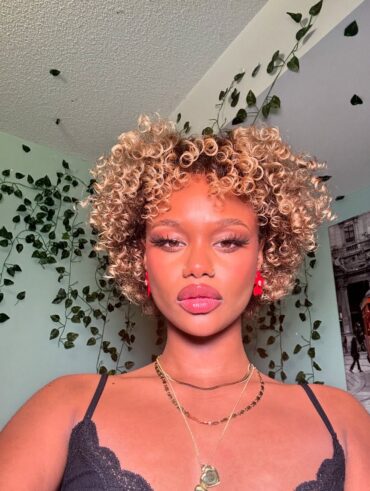 Mulher negra com cabelo curto, no estilo bob e cacheado