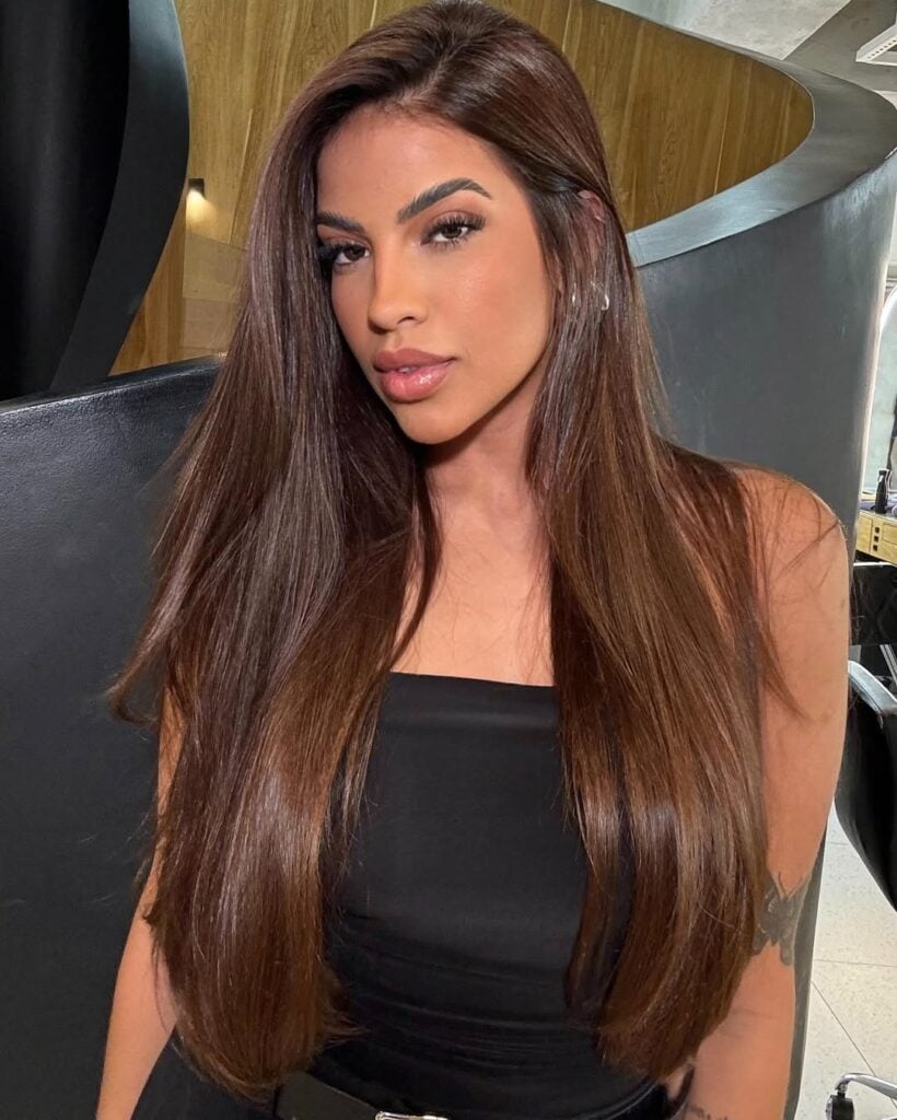 Mulher negra com cabelo longo e liso na cor chocolate