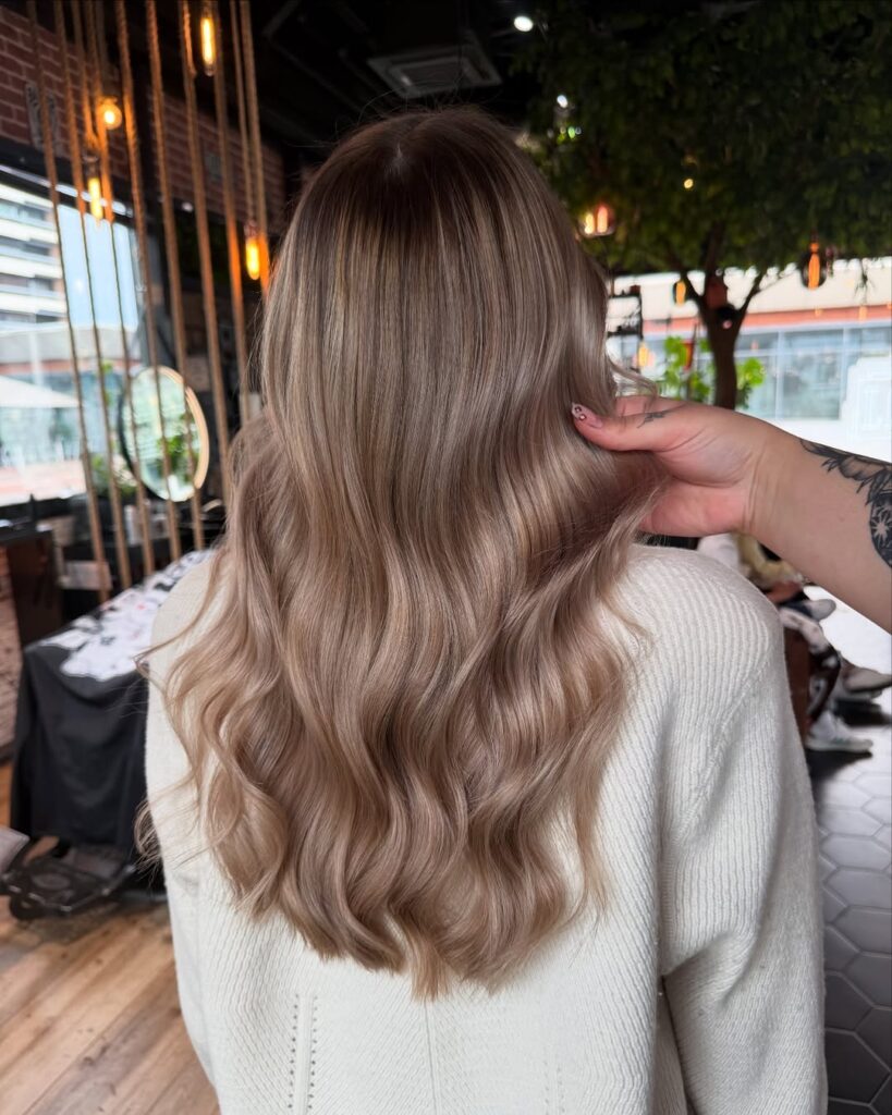 Mulher de costas, com casaco branco e cabelo com luzes
