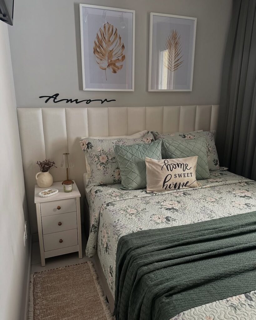 Quarto com cabeceira estofada, cama posta com colcha e fronhas florais