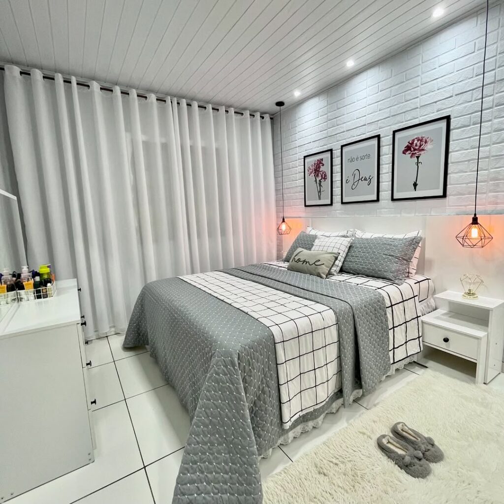 Quarto branco com três quadros acima da cabeceira, pendentes ao lado da cama