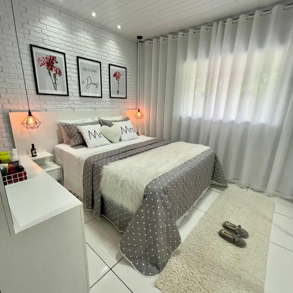 Quarto de casal com cortina branca, cama posta em cinza e branco