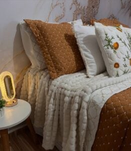 Cama posta com almofadas, colcha e manta