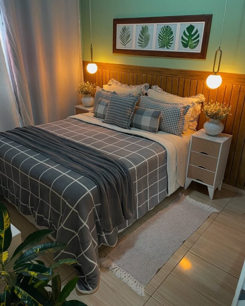 Cama com cabeceira de madeira, roupa de cama em variações de xadrez cinza, mesa de cabeceira com vaso de flores