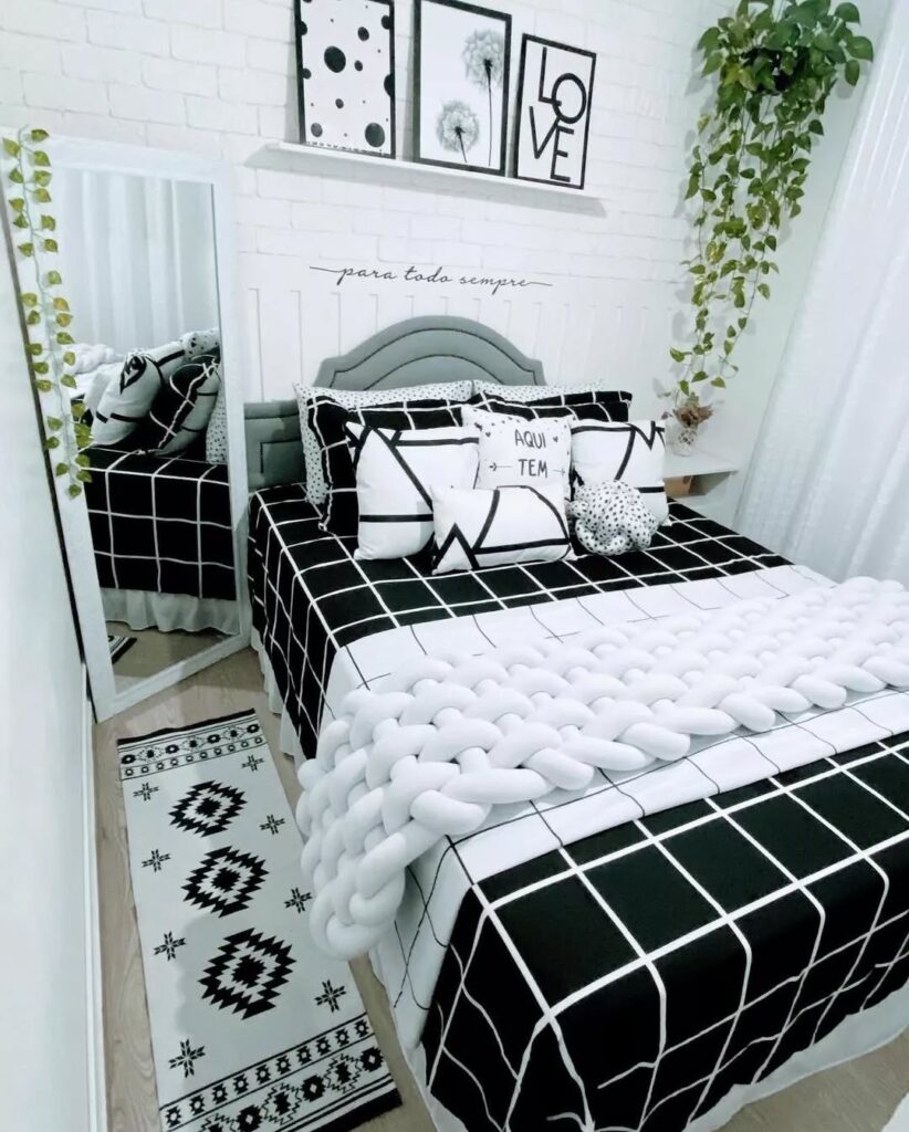 Quarto com decoração em branco, cinza e preto e plantas suspensas