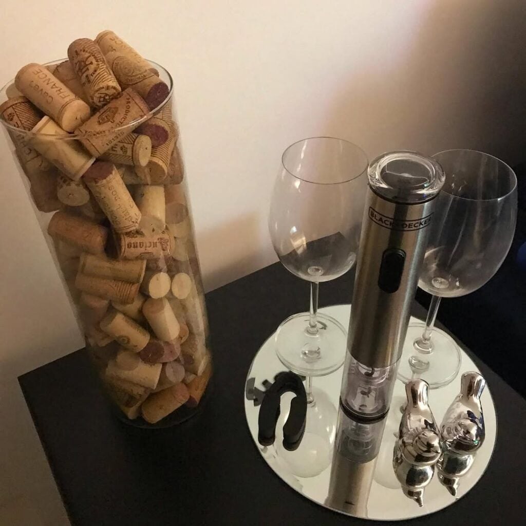 Vidro com rolhas, bandeja com taças e enfeites