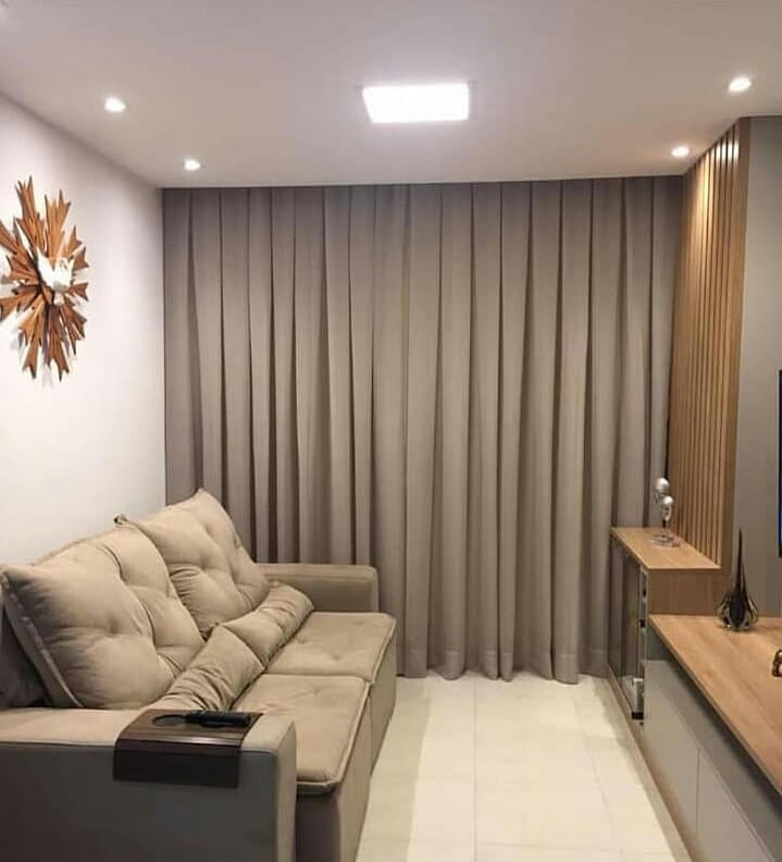 Sala com sofá e cortina em cores neutras