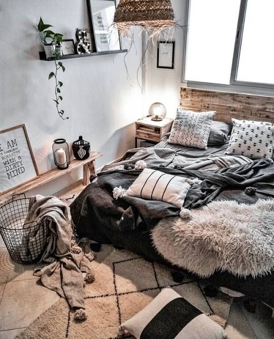 Quarto com cabeceira de madeira, mantas e almofadas