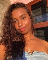Mulher negra com cabelo longo e cacheado na cor chocolate