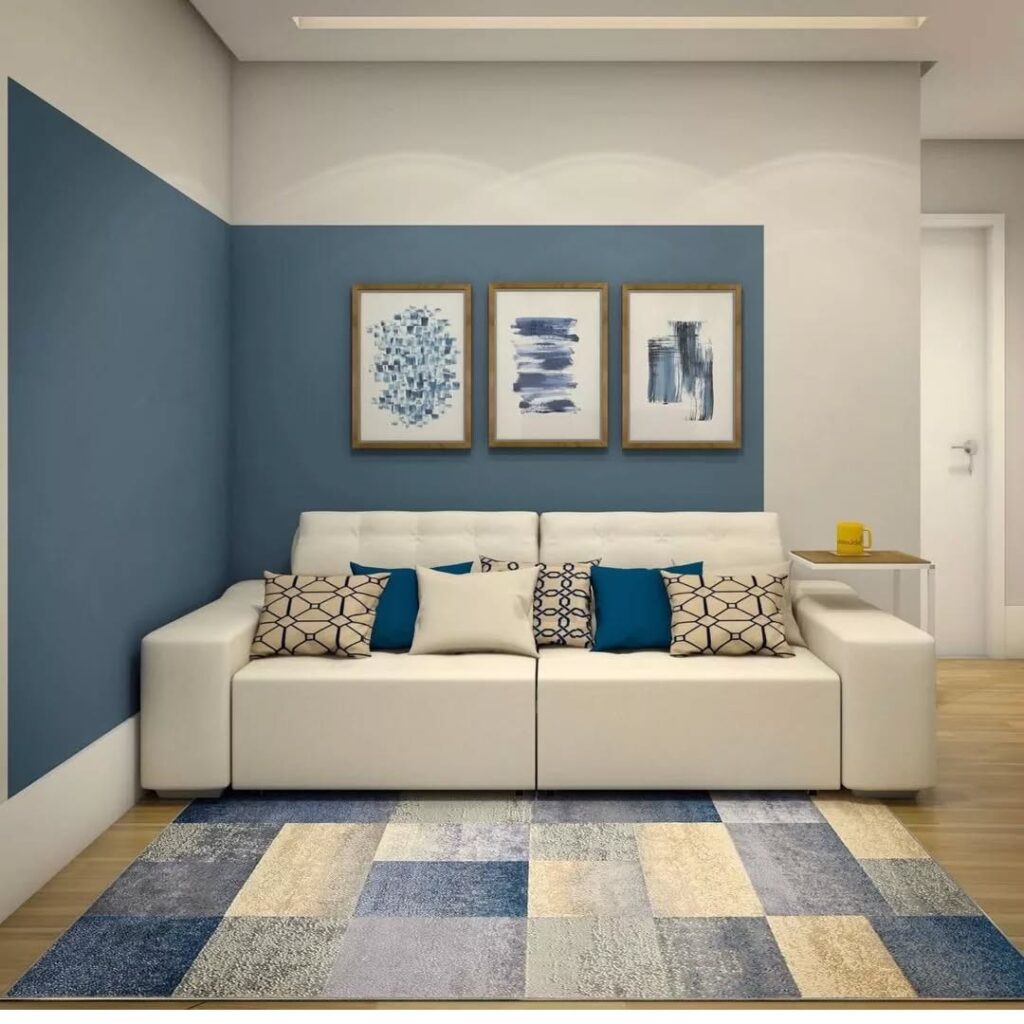 Sala com paredes e tapete azul, com sofá de linhas retas branco com almofadas coloridas