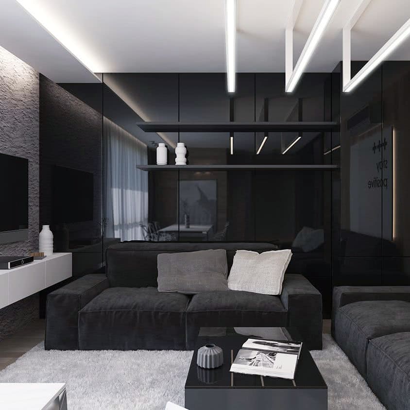 Sala com sofá e revestimentos pretos e detalhes em cinza