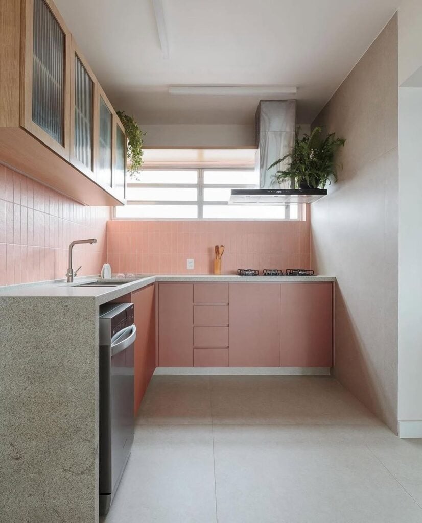 Cozinha com revestimento e armários em rosa