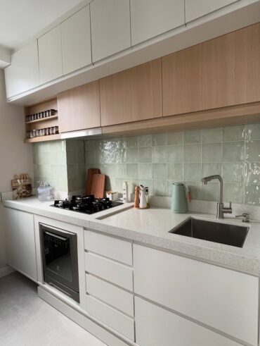 Cozinha pequena e decorada com MDF branco e de madeira, com rodabanca verde