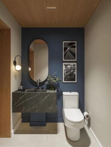 Lavabo com parede azul, espelho oval e quadros com bordas brancas