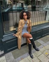 Mulher jovem sentada com look com bota de cano longo