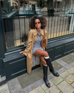 Mulher jovem sentada com look com bota de cano longo