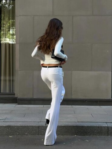 Mulher jovem com roupa branca e cinto preto fino