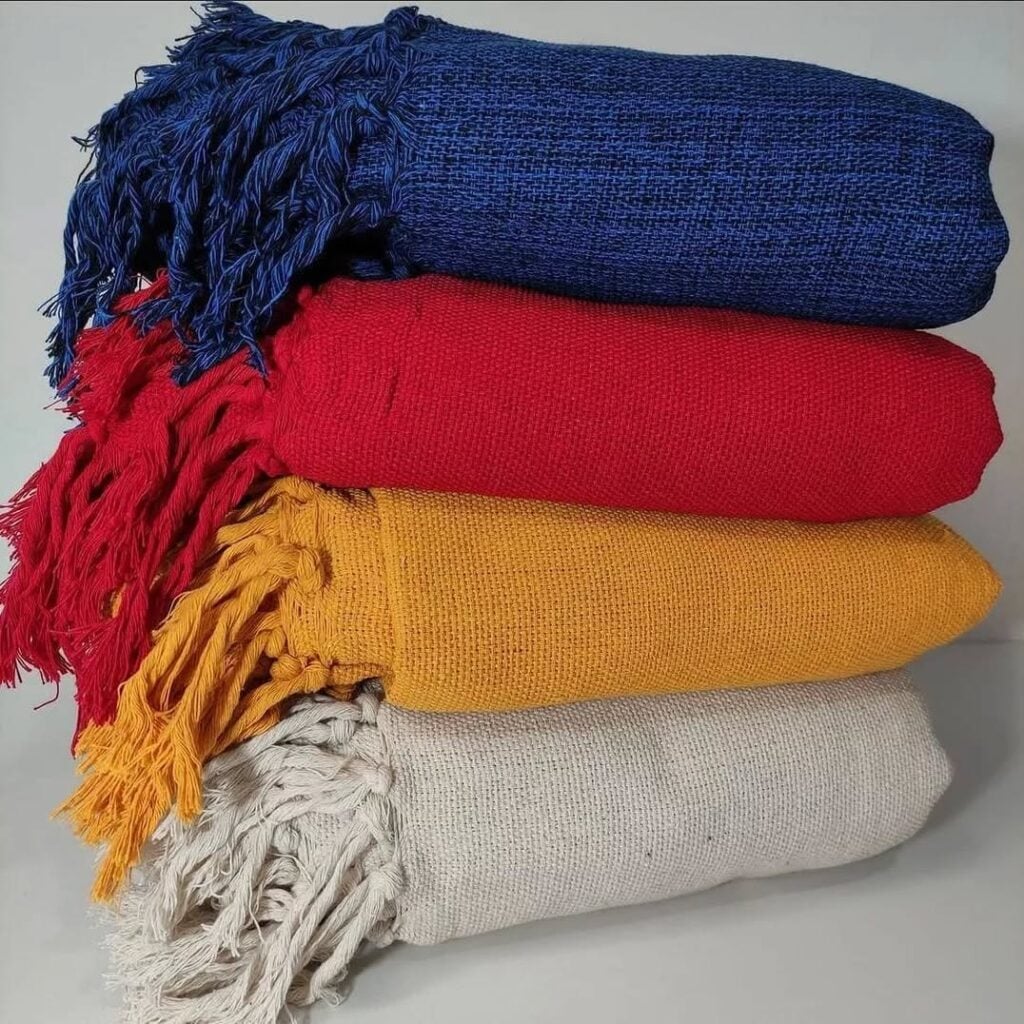 Mantas de sofá bege, amarelo, vermelho e azul-marinho